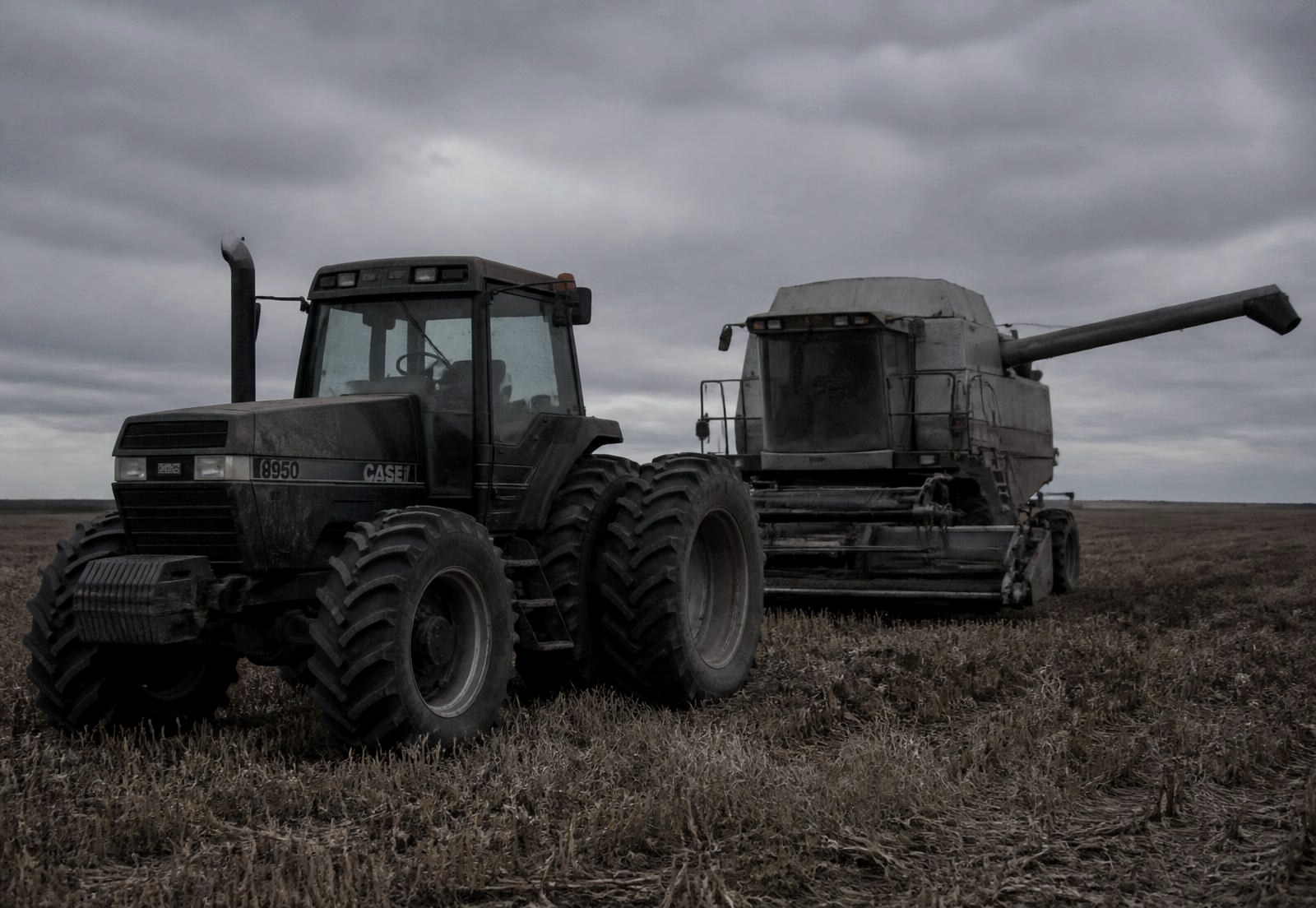 Diesel agricultural tractor and combine in an Alberta field